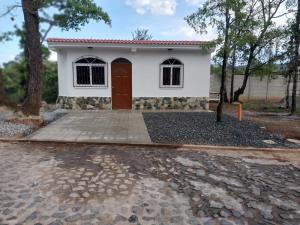 a small white house with a red door at Casita Laguna Ocubila 
