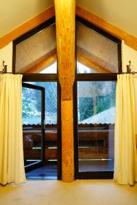 a room with two large windows with curtains at Mi Chalet - Poiana Izvoarelor in Vatra Dornei