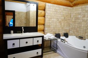 a bathroom with a tub and a sink at Mi Chalet - Poiana Izvoarelor in Vatra Dornei
