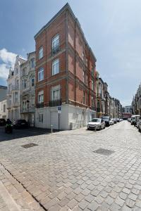 a brick building on a street with parked cars at Point du jour in Ostend