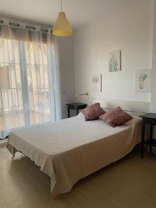 sypialnia z dużym łóżkiem i dużym oknem w obiekcie Urb. Los Collados .Águilas Apartamento w mieście Águilas