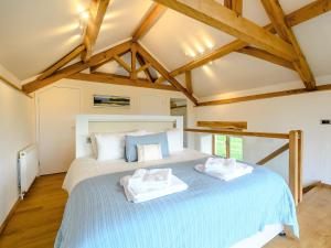 a bedroom with a large bed with two towels on it at 1 Bed in Dulverton 59339 in Knowstone