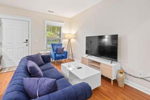 a living room with a blue couch and a tv at Affordable 2-BR Heart of Detroit in Detroit