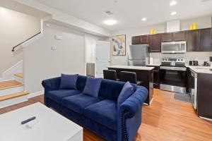 a living room with a blue couch and a kitchen at Affordable 2-BR Heart of Detroit in Detroit