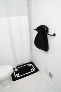 a bathroom with a toilet and a hat on the floor at Modern Minimalist Lux Paradise in Newark