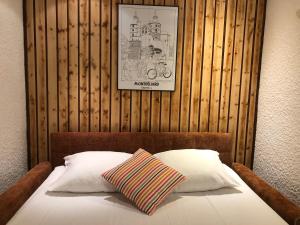 a bed with a picture on a wooden wall at Les Tilleuls Montbeliard Sud Audincourt in Audincourt