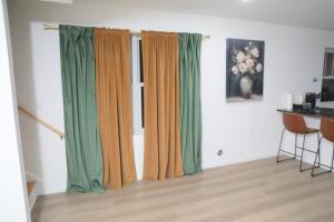 a room with green and orange curtains and a table at Modern Minimalist Lux Paradise in Newark