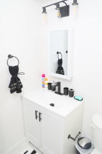 a white bathroom with a sink and a mirror at Modern Minimalist Lux Paradise in Newark