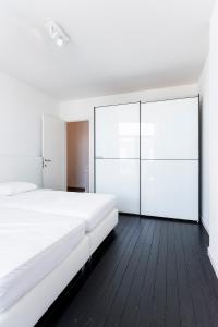 a bedroom with a large white bed and glass walls at Point du jour in Ostend +15 photos