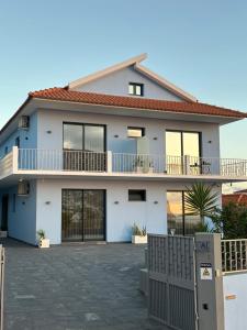 a white house with a fence in front of it at Oásis Suites - Funchal in Funchal