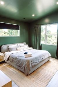 a bedroom with a large bed with a green wall at ModTrio 3BR with ensuites & Garage Mins to Uptown in Charlotte