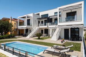 a house with a swimming pool in front of it at Olympiada Complex Calma Di Mare Apartment in Ofrínion