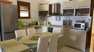 a kitchen with a table with chairs and a microwave at Lena's House Kriopigi in Kriopigi