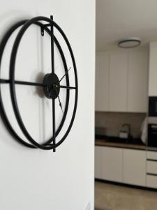 a black clock hanging on a white wall in a kitchen at Apartman Relax in Arandelovac +35 photos