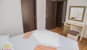 a bedroom with a white bed with a mirror at Lotos - stan 423 in Dobra Voda