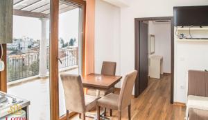 a dining room with a table and chairs and a balcony at Lotos - stan 423 in Dobra Voda