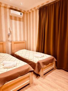 トビリシにあるIceberg Hotelのツインベッド2台と窓のある寝室