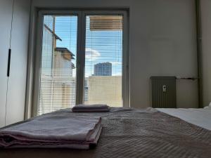 une chambre avec un lit et une grande fenêtre dans l'établissement Modern Flat in Prishtina Centre, à Pristina