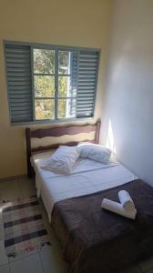 una camera da letto con un letto grande con una finestra di Pousada Refúgio da Serra a São Thomé das Letras