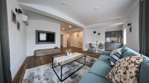 a living room with a blue couch and a table at Pera Apartments in Cristian