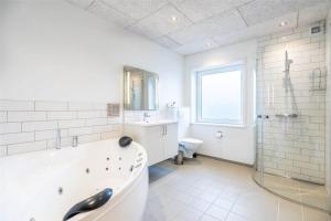a white bathroom with a tub and a toilet at 804-Hvide-Sande-Havnegade-2-1-A in Hvide Sande +20 photos
