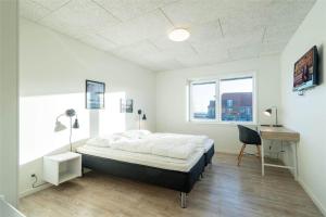 a bedroom with a bed and a desk and a window at 804-Hvide-Sande-Havnegade-2-1-A in Hvide Sande
