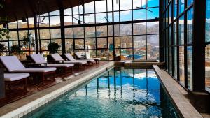 a pool in a building with chairs and windows at Atix Hotel, a Member of Design Hotels in La Paz