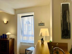 a living room with a table and a window at The Duplex des Flots In the heart of Grandcamp just steps from the beach in Grandcamp-Maisy