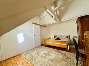 an attic room with a bed and a rug at The Duplex des Flots In the heart of Grandcamp just steps from the beach in Grandcamp-Maisy