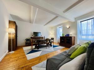 a living room with a couch and a table at The Duplex des Flots In the heart of Grandcamp just steps from the beach in Grandcamp-Maisy