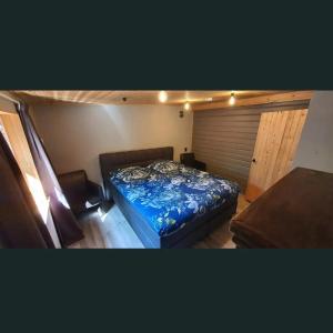 a bedroom with a bed with a blue comforter at Finse woning nabij groot meer in Rohel