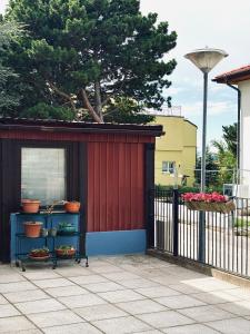 a red building with shelves next to a fence at Sunlit Apartment with Garden, Next to Station, Vienna in Vösendorf