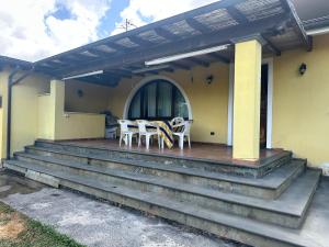 a porch with chairs and a table on a house at La Paulonia Country House in Capezzano Pianore,