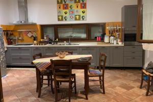 a kitchen with a table and chairs in it at La Paulonia Country House in Capezzano Pianore, +22 photos