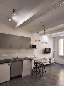 an empty kitchen with a counter and a table at Aix Centre-ville in Aix-en-Provence