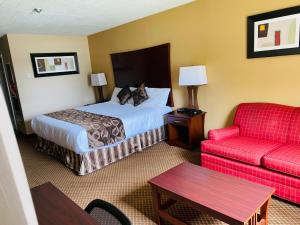 a hotel room with a bed and a red couch at Luxury Inn in Collingwood