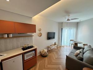 a living room with a couch and a kitchen and a table at Summit Flat São José dos Campos in São José dos Campos