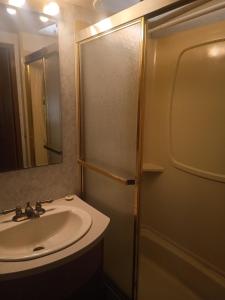a bathroom with a sink and a shower with a mirror at Motorhome Casa rodante in San Mateo Río Hondo