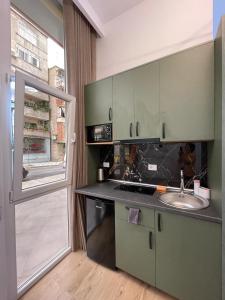 a kitchen with a sink and a counter with a window at What's Up Tirana in Tirana