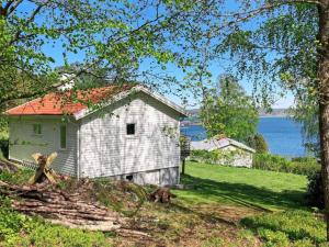 an old white house with a red roof next to the water at 4 person holiday home in H viksn s in Höviksnäs