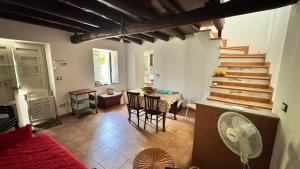 a living room with a table and chairs and stairs at La casa di Filippo e Filippa in Gioiosa Marea