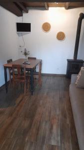 ein Wohnzimmer mit einem Tisch und einem Holzofen in der Unterkunft Casa do Freire - Serra da Estrela in Aguincho + 13 Fotos