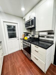 a kitchen with white cabinets and a stove top oven at Emperors Pool House in Jacksonville