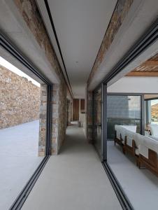 a room with glass doors and a brick wall at Katokia Kokkina in Finikas