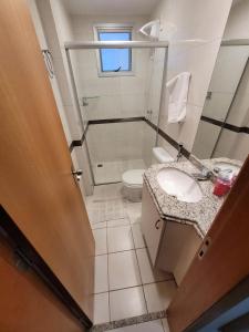 a bathroom with a toilet and a sink at Imprensa III · Comfort and family in Brasilia in Brasilia