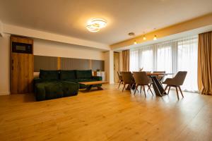 ein Wohnzimmer mit einer grünen Couch und einem Tisch in der Unterkunft Mountain Serenity and Charming Old Town Nearby by MM Host in Braşov