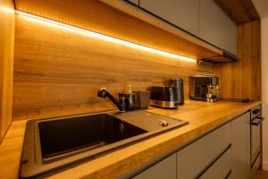 eine Küchentheke mit Spüle und Kaffeemaschine in der Unterkunft Mountain Serenity and Charming Old Town Nearby by MM Host in Braşov + 50 Fotos