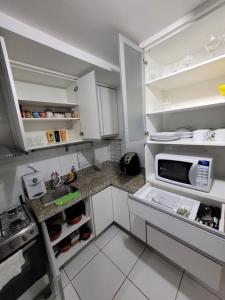 a kitchen with white cabinets and a microwave at Imprensa III · Comfort and family in Brasilia in Brasilia