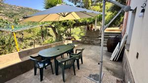 a table and chairs and an umbrella on a patio at La casa di Filippo e Filippa in Gioiosa Marea