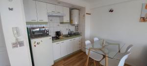a kitchen with a refrigerator and a table and chairs at Rbkº Acogedor depto cercano a Playa Amarilla in Concón